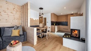 Una sala de estar moderna con sofá, mesa de comedor y zona de cocina.