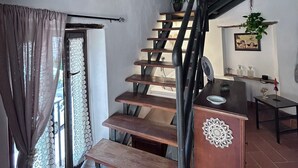 A staircase with wooden steps and a metal railing leading to a landing.