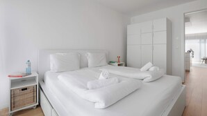 A hotel room with a large bed, a wardrobe, a bedside table, and a small bedside shelf. - Superior Cityline Suite (Vienna)