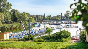 A marina with boats docked, surrounded by greenery and buildings in the background. - Superior Cityline Suite (Vienna)