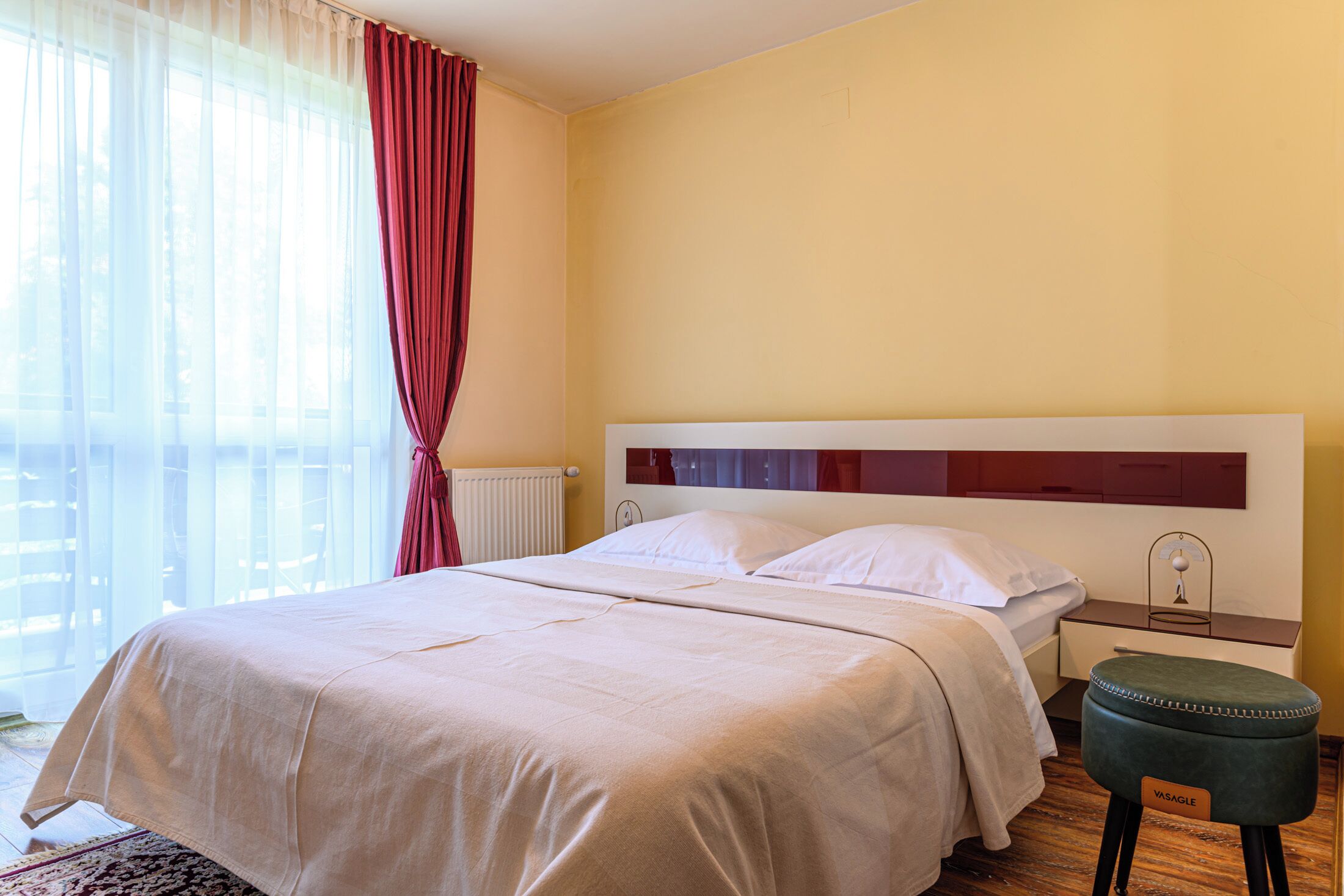 Una habitación de hotel con una cama grande, una mesita de noche y una ventana con cortinas.