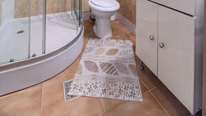 A modern bathroom with a glass-enclosed shower, a toilet, a sink, and a mirror. - Tranquil 1-bedroom house in Bușteni (Bușteni)