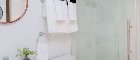Un baño moderno con inodoro, lavabo y zona de ducha.
