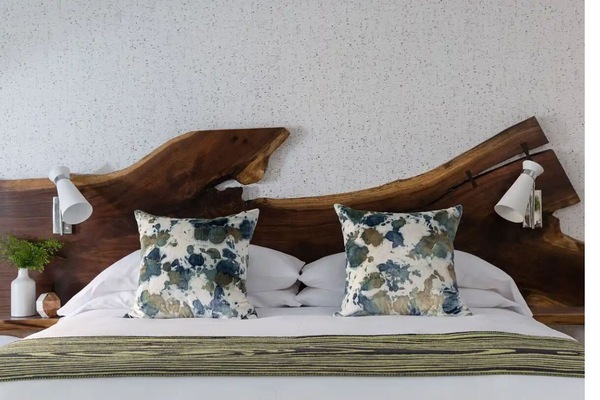 Sink into crisp linens beneath a sculpted, wooden headboard.
