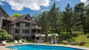 A hotel with a swimming pool, outdoor seating, and a forested area. - Enjoy Nature & Town | Stay in Style at Field Guide Lodge, Close to Everything (Stowe)