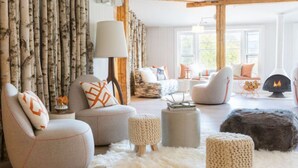 A cozy living room with round armchairs, a fireplace, and a large window. - Enjoy Nature & Town | Stay in Style at Field Guide Lodge, Close to Everything (Stowe)