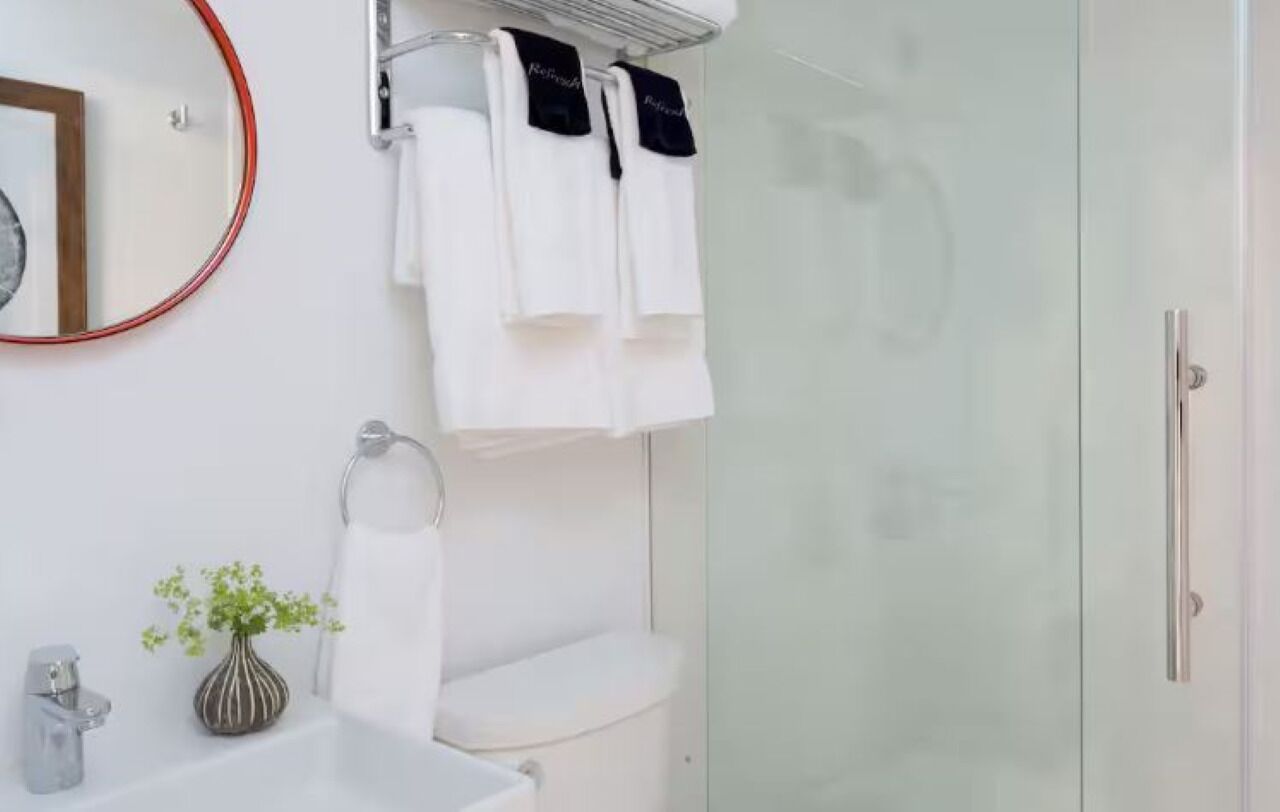 A modern bathroom with a toilet, sink, and shower area.