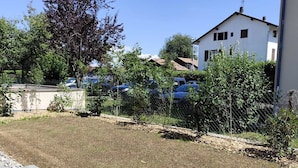 Un quartier résidentiel avec une allée pavée, une pelouse et un bâtiment blanc doté de nombreuses fenêtres et d’une cheminée.