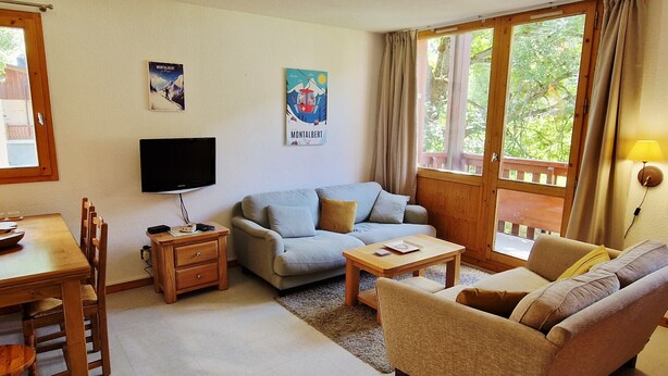 A cozy living room with a sofa, a coffee table, a TV, and a dining area with chairs and a table. - 3-room apt, 6-8 people, near slopes - La Plagne Montalbert (La Plagne Montalbert)