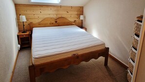 A bedroom with a wooden headboard, a single bed, two bedside lamps, a small wooden nightstand, and a skylight above the bed. - 3-room apt, 6-8 people, near slopes - La Plagne Montalbert (La Plagne Montalbert)