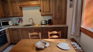 A kitchen with wooden cabinets, a microwave, a toaster, and a sink. - 3-room apt, 6-8 people, near slopes - La Plagne Montalbert (La Plagne Montalbert)