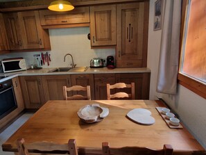 Eine Küche mit Holzausstattung, einer Mikrowelle, einem Toaster und einem Spülbecken.