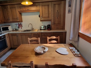 A kitchen with wooden cabinets, a microwave, a toaster, and a sink.