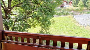 A wooden bench overlooking a grassy area with a tree and a building in the background. - 3-room apt, 6-8 people, near slopes - La Plagne Montalbert (La Plagne Montalbert)