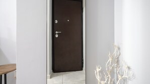 Puerta cerrada con un ojo de cerradura y un cerrojo, pared blanca y piso blanco.