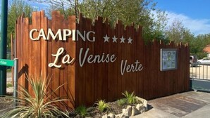 Een houten bord met de tekst 'CAMPING La Venise Verde'.