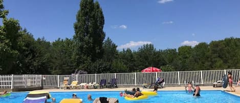 Ein Poolbereich mit Liegestühlen und Sonnenschirmen.