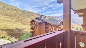 Una cabaña de madera con varios balcones y vistas a la montaña.