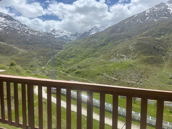 Eine gebirgige Landschaft mit einer Straße und einem Strommasten.