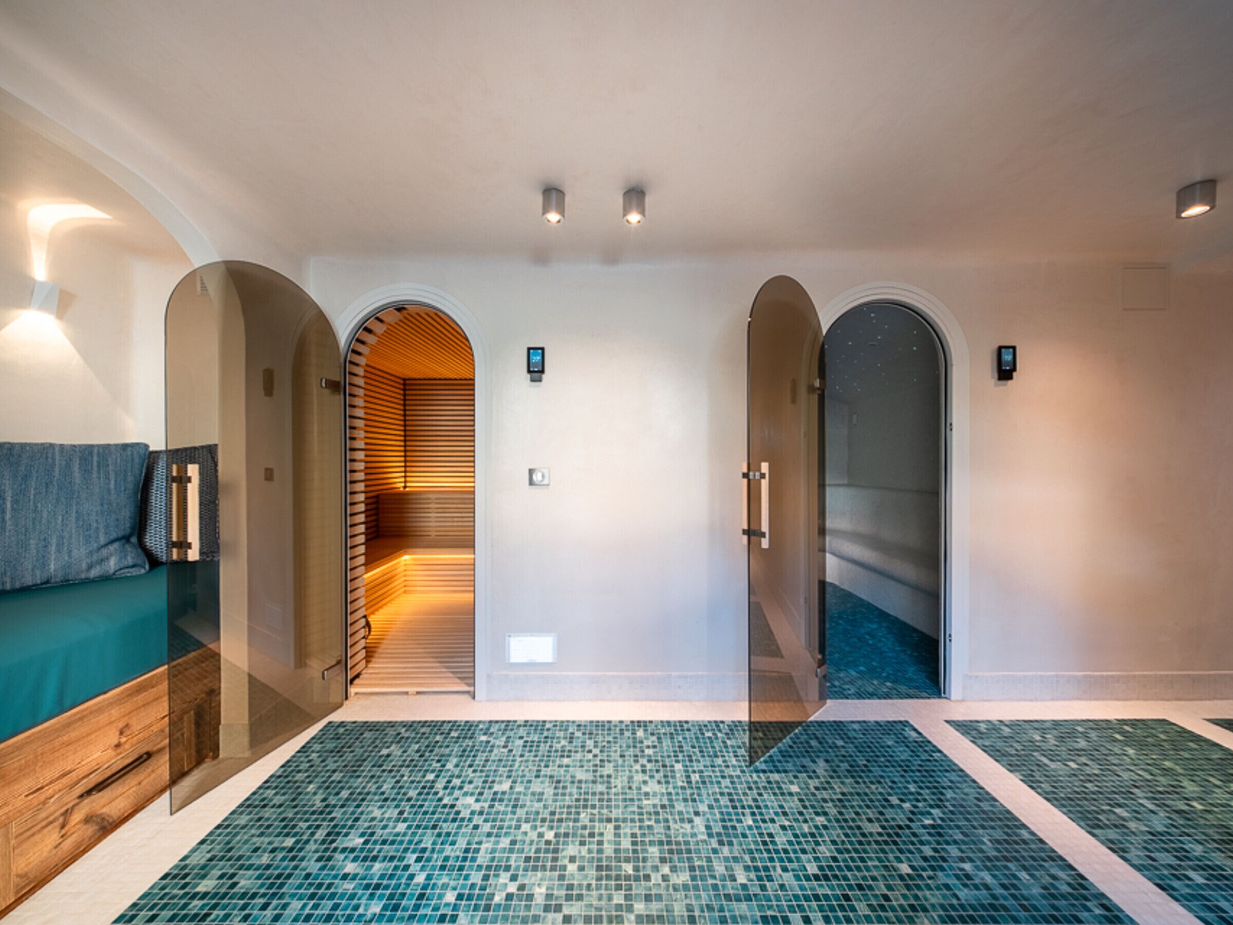 Eine Hotelhalle mit Glastrennwand, einer Rezeption und einem Fliesenboden.