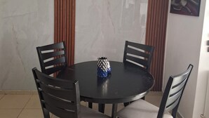A dining area with a round table, four chairs, a ceiling fan, and a wall-mounted painting. - Charming 3 Bedroom Apartment in San Miguelito, Panama City (San Miguelito)