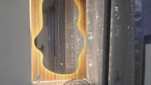 A room with a wooden panel wall, a large mirror, and a coiled cable on a stand. - Charming 3 Bedroom Apartment in San Miguelito, Panama City (San Miguelito)