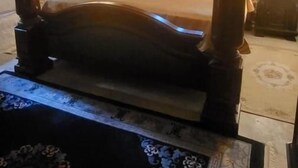Een kamer met een hemelbed, stenen muren en een schuine balkenkap.