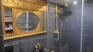 Een moderne badkamer met een wastafelmeubel, een ronde spiegel en een douche met glazen wanden.
