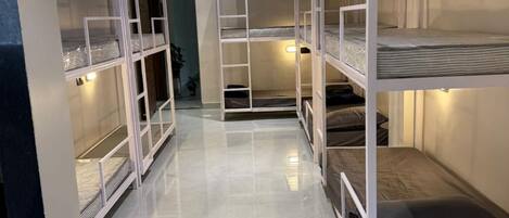 A bunk room with multiple bunk beds, a ceiling fan, and a ladder.