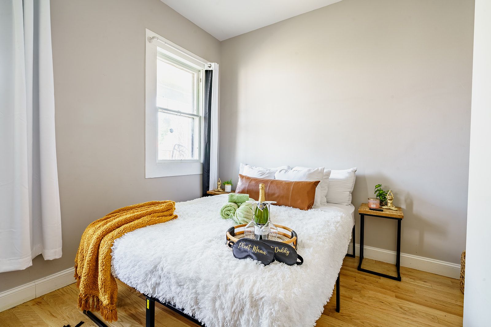 A bedroom with a bed, a window, a bedside table, and a nightstand.