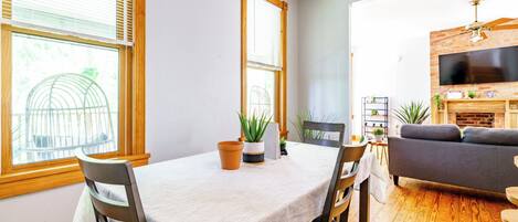 A dining area with a table, chairs, and potted plants.