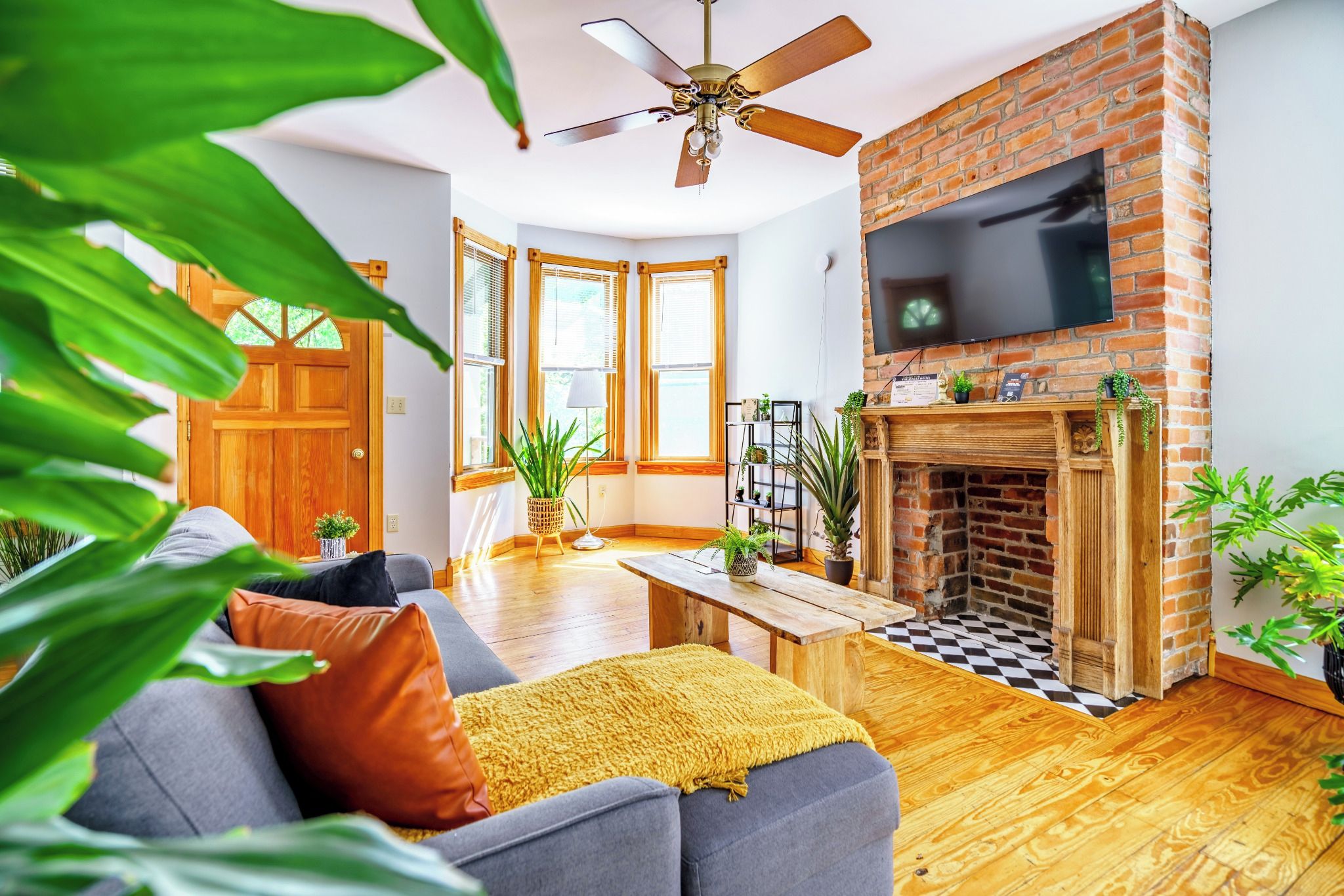 A living room with a fireplace, a sofa, a coffee table, and a TV mounted on the wall.