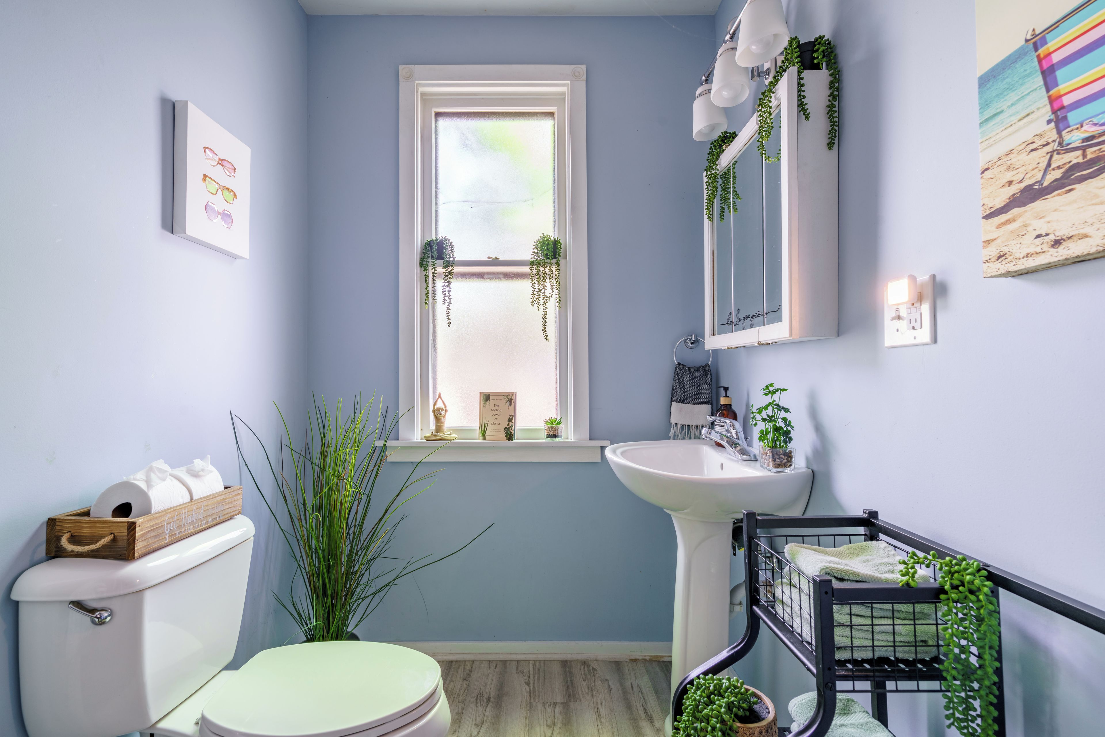 Une salle de bain avec des toilettes, un lavabo et une fenêtre.