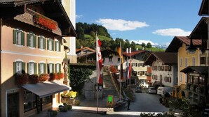 Una calle típica de un pueblo europeo, con edificios, una escalera y banderas.