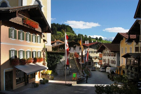 A traditional European village street with buildings, a staircase, and flags. - Alpine Escape in Hopfgarten (Hopfgarten im Brixental)