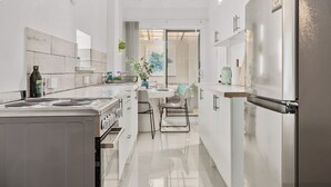 A modern kitchen with a central island, stainless steel appliances, and a view into the dining area. - Your Private Coastal Escape | Steps from Shoalwater Beach (Shoalwater)