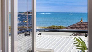 A balcony with a view of the sea, a tiled roof, and a potted plant. - Your Private Coastal Escape | Steps from Shoalwater Beach (Shoalwater)