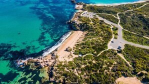 An aerial view of a coastal area with a winding road, beach, and rocky coastline. - Your Private Coastal Escape | Steps from Shoalwater Beach (Shoalwater)