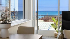 A room with a large window overlooking a beach and ocean. - Sea view Retreat - Spot Dolphins (Shoalwater)