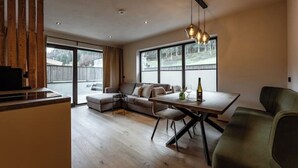 A modern living space with a dining area, a sofa, and a TV.