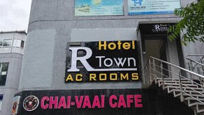 A hotel named "Hotel Town AC Rooms" with a sign for "Chai-Vaa Cafe" below it. - Hotel R Town (Vadodara)
