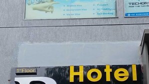 A sign for "R Town AC Rooms" on the 1st floor of a building. - Hotel R Town (Vadodara)
