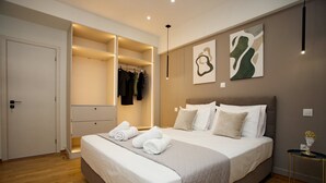 Een moderne slaapkamer met een groot bed, een inloopkast en kunstwerken aan de wanden.