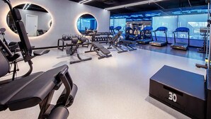 A modern gym with various exercise equipment, including treadmills and weight machines. - Hamilton House Studio: Rooftop Pool & Gym Access (Dubai)
