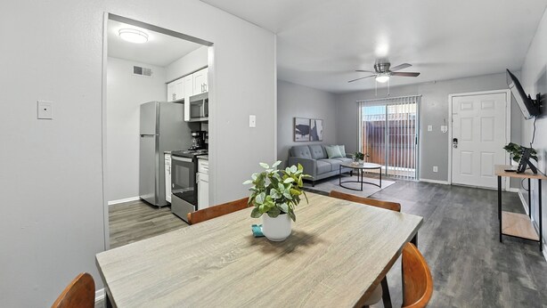 Un apartamento moderno con comedor, cocina, sala de estar y una escalera.