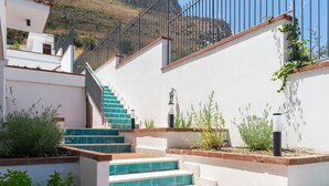 A staircase with blue steps leading up to a balcony, surrounded by white walls and greenery. - Casa Solunto Vista Mare by Wonderful Italy (Santa Flavia)