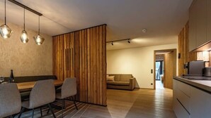 A modern kitchen with wooden cabinets and a dining area with a table and chairs. - Top 7 Geislhorn (Sankt Ulrich am Pillersee)