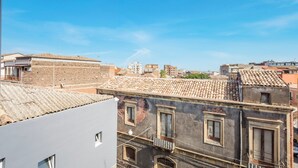 A view of a cityscape with buildings, including a building with a tiled roof and multiple windows. - Room 'Garibaldi - Matrimoniale' with Balcony, Wi-Fi and Air Conditioning (Catania)