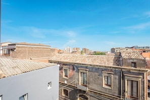 A view of a cityscape with buildings, including a building with a tiled roof and multiple windows.