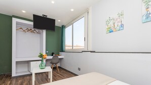 A room with a bed, a desk, a chair, a TV, and a window. - Room 'Garibaldi - Matrimoniale' with Balcony, Wi-Fi and Air Conditioning (Catania)